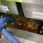 A person holding house that is placed inside a grease trap