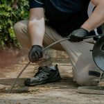 A man holding a camera or hose to inspect a drain