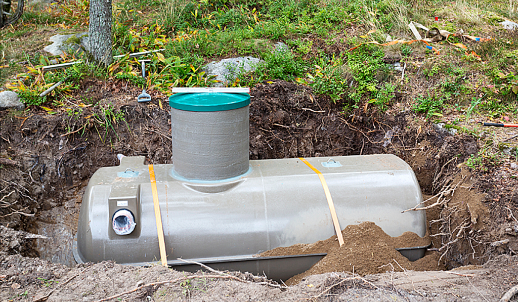 An uncovered septic tank sitting in the ground