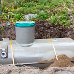 An uncovered septic tank sitting in the ground