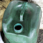 Used oil container with an open lid, showing a waste oil storage drum awaiting collection and disposal.
