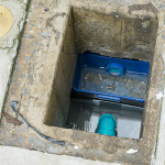 Open grease trap chamber showing wastewater, internal baffle components and pipework during routine inspection and maintenance.