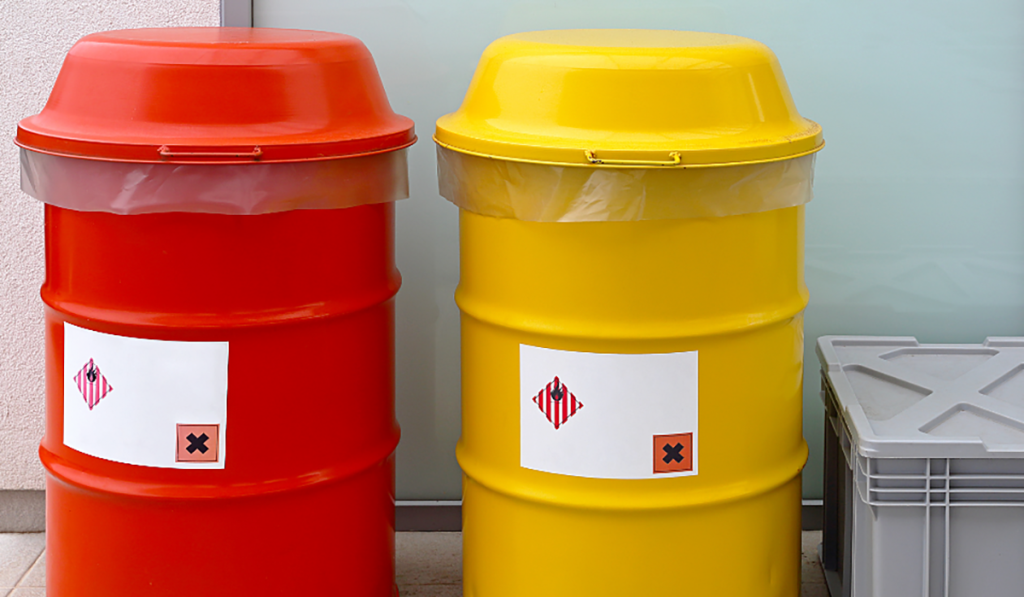 Red and yellow chemical waste drums with hazardous material labels