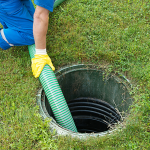 Worker pumping a septic tank with a vacuum hose