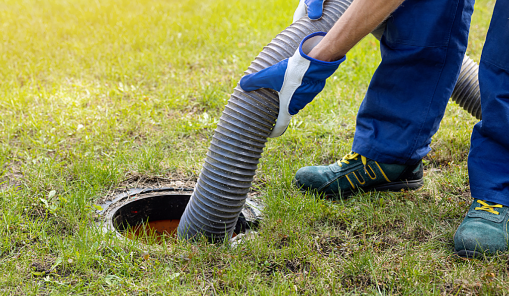 Septic tank being pumped using a vacuum hose