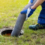 Septic tank being pumped using a vacuum hose